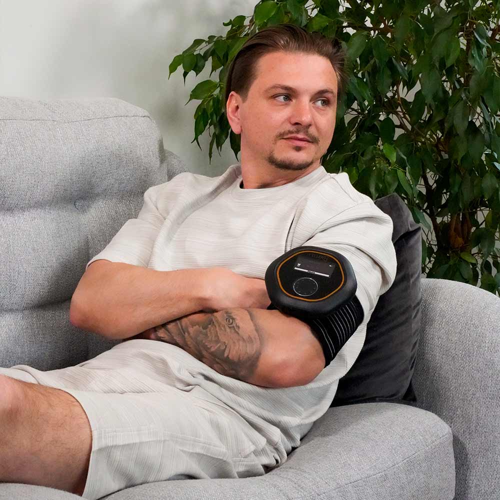 Wearing CELLER8 PEMF device on sofa on arm