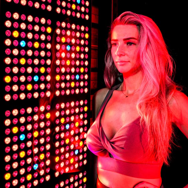 Women stood next to full body red light panel 