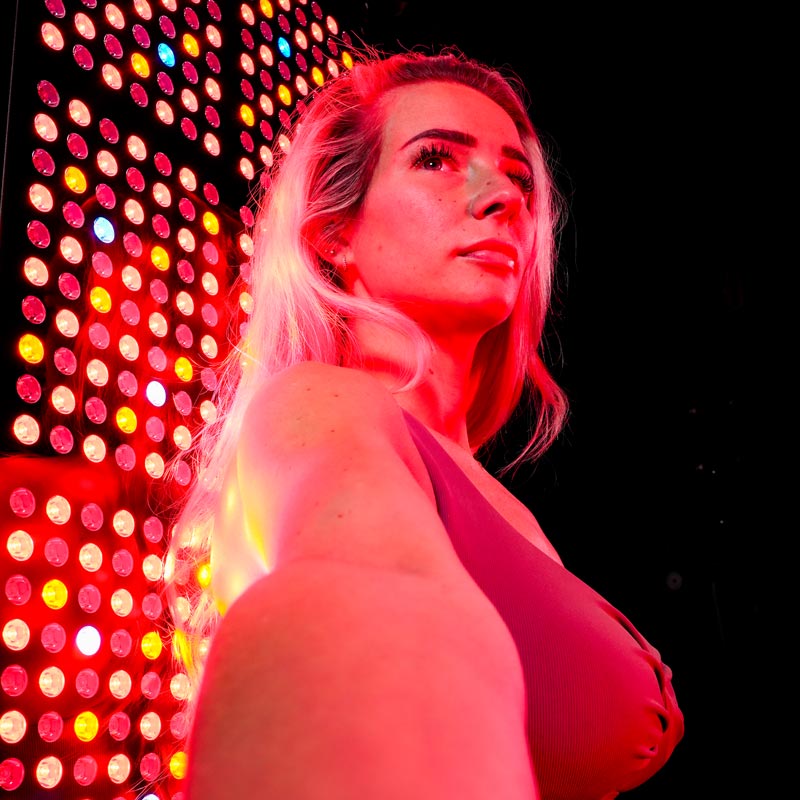 Women in front of red light panel 