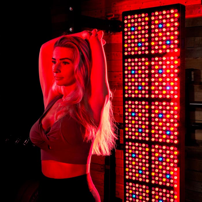 Women stretching in front of CELLER8 full body red light panel